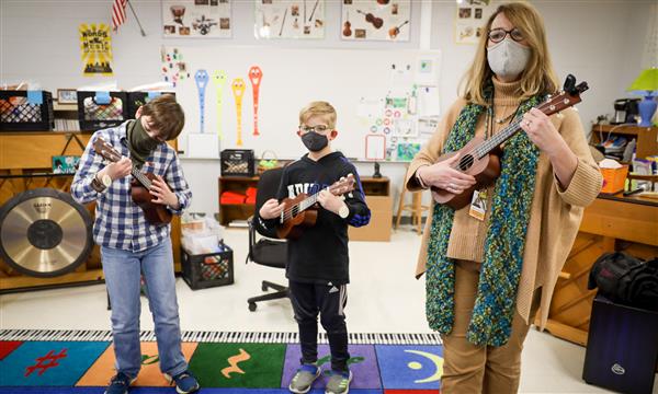 teacher and students play ukulele